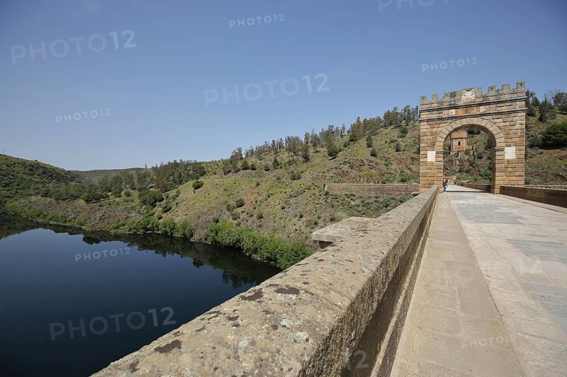 Roman bridge Puente Romano with Torre del Oro arch and gold tower, Rio Tajo river, landscape, Alcantara, Extremadura, Spain