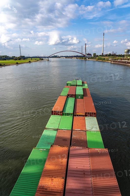 The Dutch cargo ship Vrido, loaded with containers, on the Rhine near Duisburg, descending, behind the so-called bridge of solidarity over the Rhine, near Duisburg-Rheinhausen, North Rhine-Westphalia, Germany