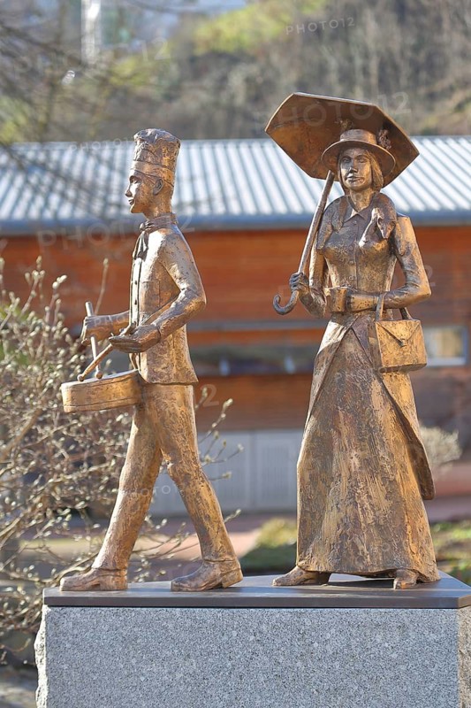 Two golden sculptures Kaffeetante and Kaffeetrommler by Walter Haaf 2022, drummer, drum, golden, male figure, female figure, lady with parasol and historical clothing, Swabian-Alemannic carnival, fools' fountain, Wolfach, Ortenau, Southern Black Forest, Black Forest, Baden-Württemberg, Germany