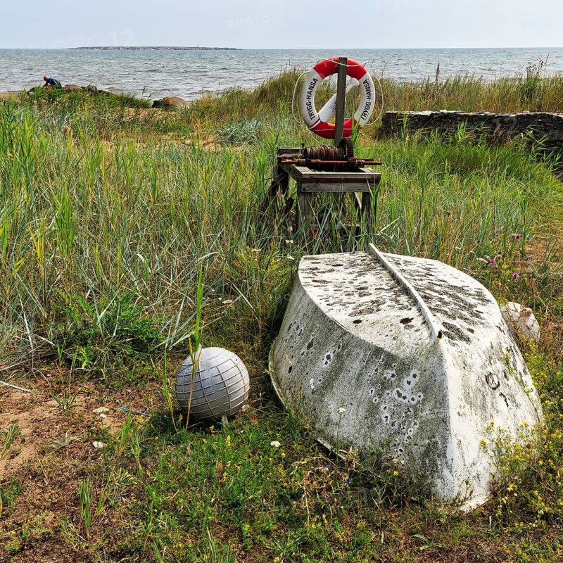 Inverted weathered boat, buoy, winch, lifebuoy on the shore, berth, fishing spot, Norebod Fiskeläge, Burgsvik, South Gotland, island of Gotland, Baltic Sea, Sweden