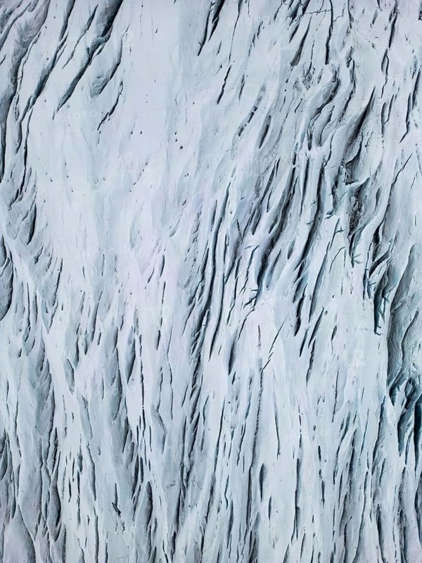 Aerial view of the Icelandic winter landscape, capturing the intricate patterns of snow-covered terrain from a drone. The pristine white surface showcases nature's raw, untouched beauty, Ã–rÃ¦fi, Austurland, Islandia