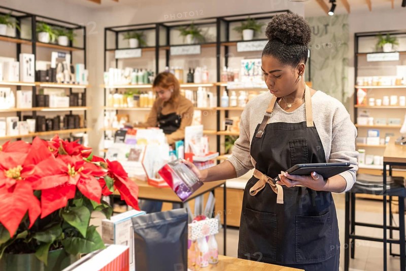 Employees organize and manage a variety of beauty products in a vibrant cosmetics store. Surroundings include lush plants and decorative elements, creating a welcoming atmosphere