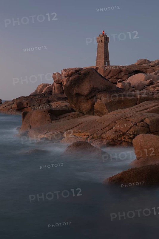 Lighthouse Mean Ruz at Ploumanach, Cotes d'Armor in the last evening light, with light on