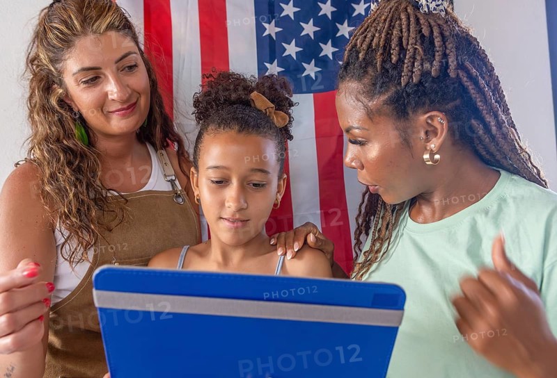 A loving lesbian family enjoys time together. Two mothers support their daughter, exemplifying diversity and identity in their warm home environment