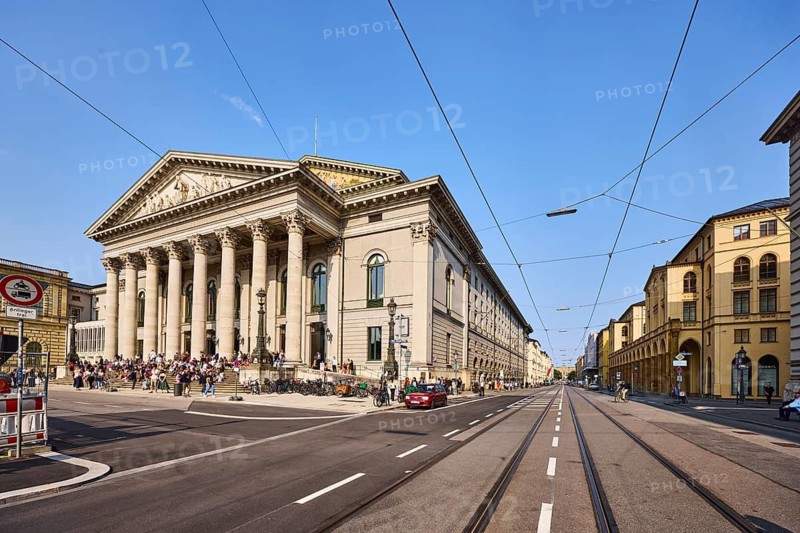 National theatre, historic opera house, classicism style, architect Karl von Fischer, entrance, gable triangle, pillars, Bavarian State Opera, general architecture, street, parking strip with vehicle, tram tracks, overhead lines, pedestrians as a secondary motif, blue sky, cloudless, Maximilianstraße junction with Max-Joseph-Platz, Munich, state capital, district-free city, Bavaria, Germany