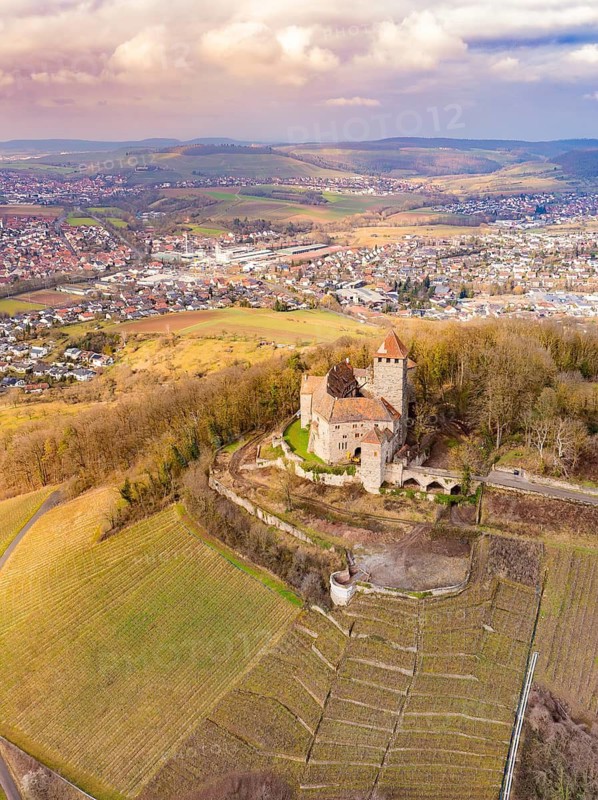 A view of the castle towering majestically over the fields, overlooking tree-lined hills, Lichtenberg Castle, Oberstenfeld, Germany