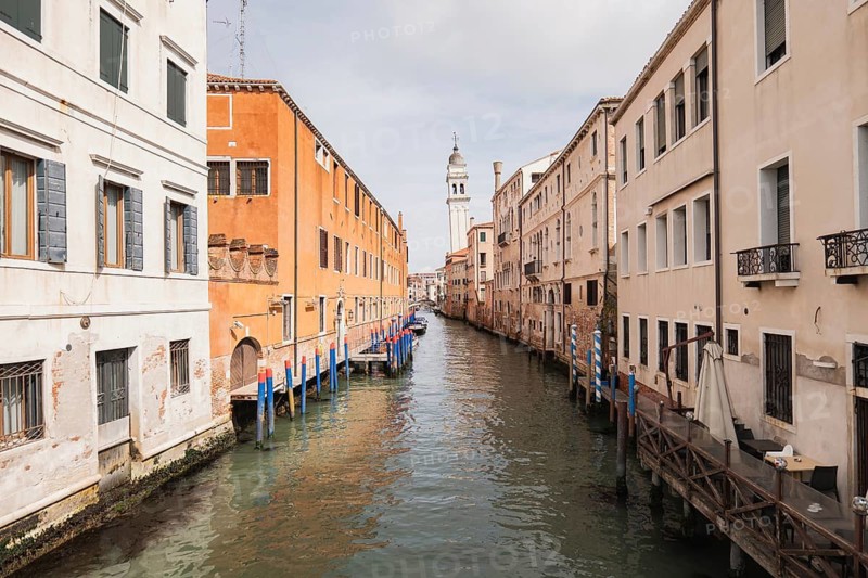 Serene Venice canal flanked by historical buildings with elegant facades. The scene captures enchanting reflections and the timeless charm of Italian architecture