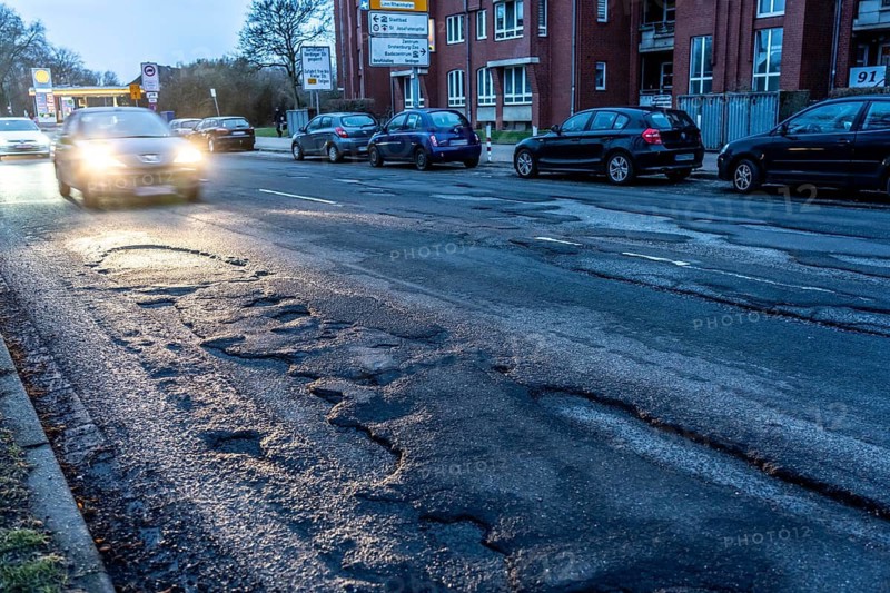 Many large potholes on an inner-city road, Lange Straße in Krefeld-Uerdingen, the heavily frequented road consists of more potholes than intact asphalt, road damage, vehicles can barely avoid, North Rhine-Westphalia, Germany