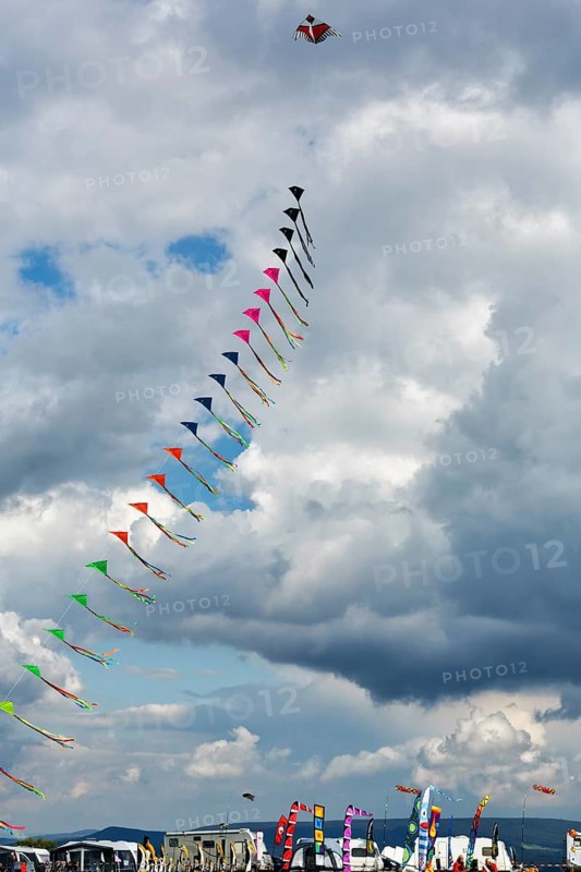 Colourful, strung kites flying in the sky, garland, kite festival in Vinsebeck, mobile homes, Steinheim, Eggegebirge and Southern Teutoburg Forest nature park Park, Weserbergland, North Rhine-Westphalia, Germany