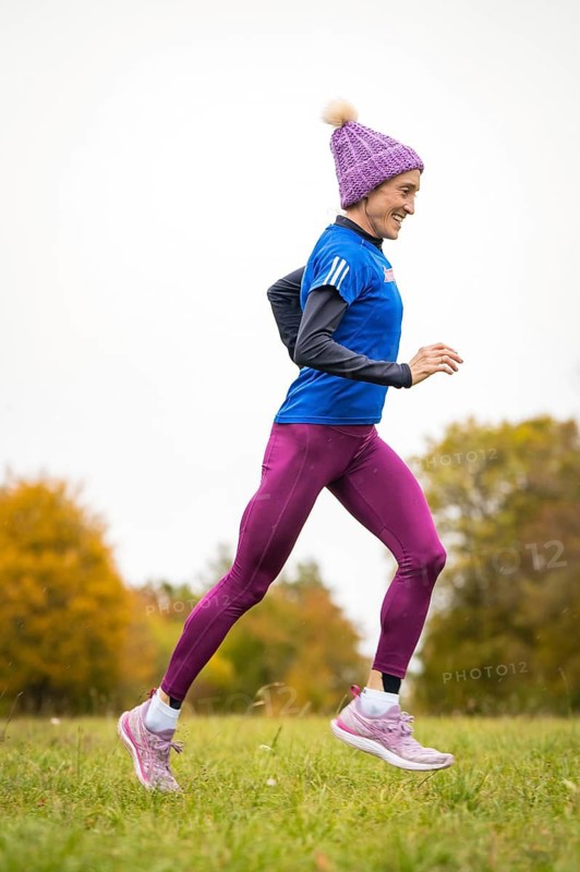 Happy woman jogging in autumn forest with vivid colours, Gechingen, Black Forest, Germany
