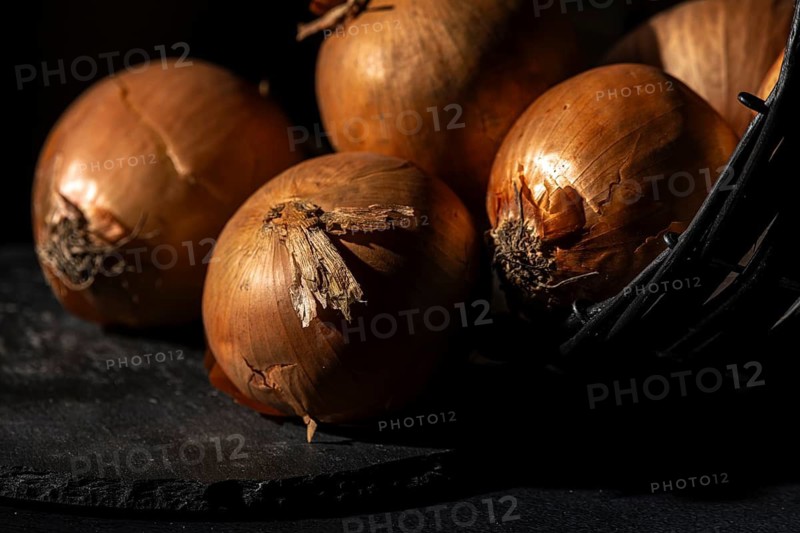 Onions in a basket, lit up in a warm, rustic atmosphere