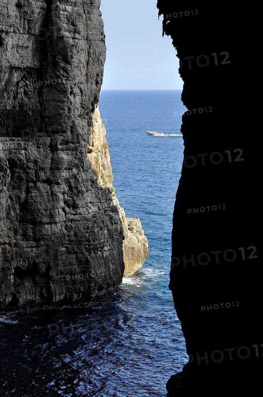 Karst cave Grotta del Turco, Cave of the Turk, Montagna Spaccata, Split Mountain, Gaeta, Tyrrhenian Sea with speedboat, Latina, Lazio, Italy