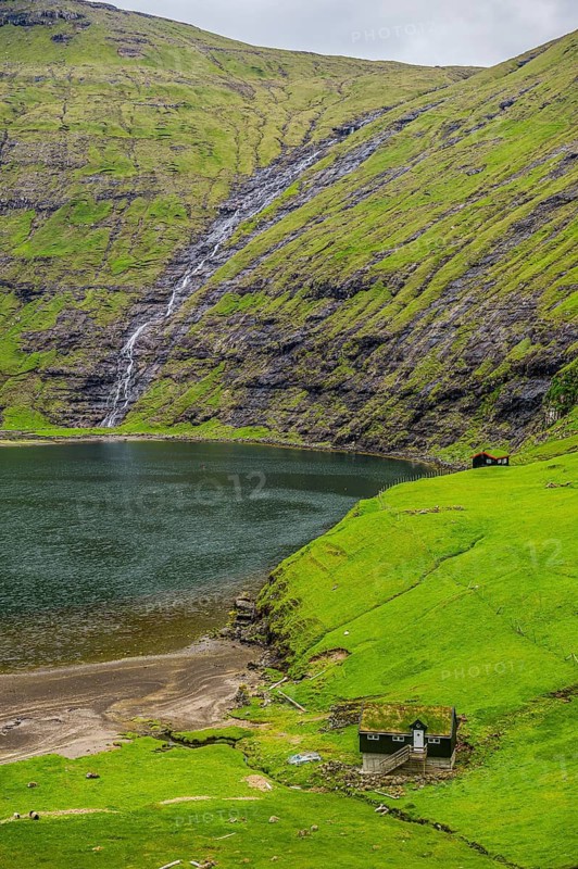 Grasstop roof house before a waterfall, Saksun, Streymoy, Faroe islands, Denmark