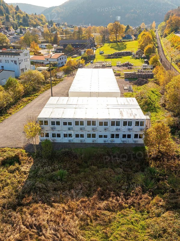 Commercial area surrounded by autumn vegetation in bird's eye view, refugee accommodation Beermiß, Calmbach, Black Forest, Germany