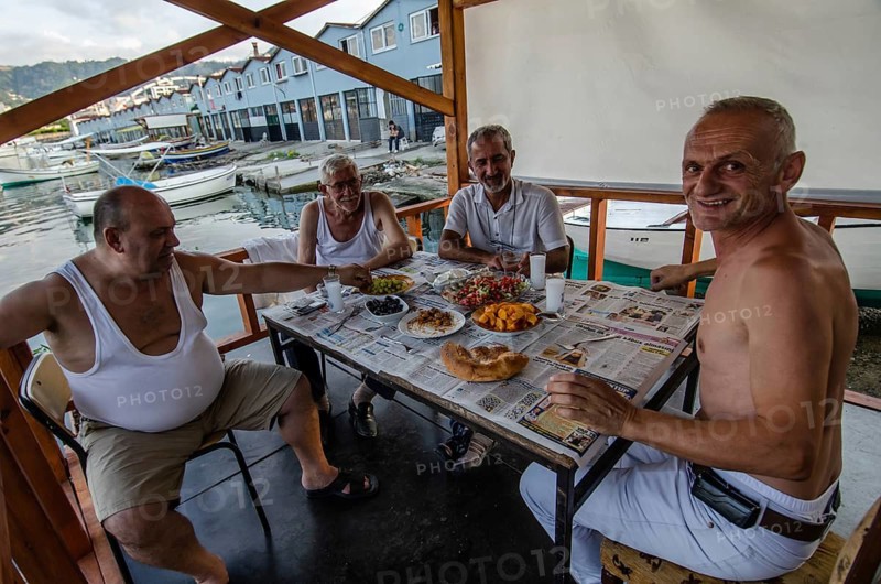 Trabzon, Turkey. 6th September 2014 Turkish fishermen enjoy a traditional Mezze with Raki in the harbour of a Trabzon village on the Black sea coast of Turkey