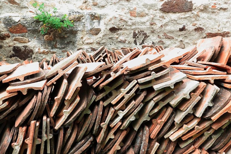 Old roof tiles stored on stockpiles for reuse on historic buildings and heritage-protected houses, beaver tail tiles, clay tiles