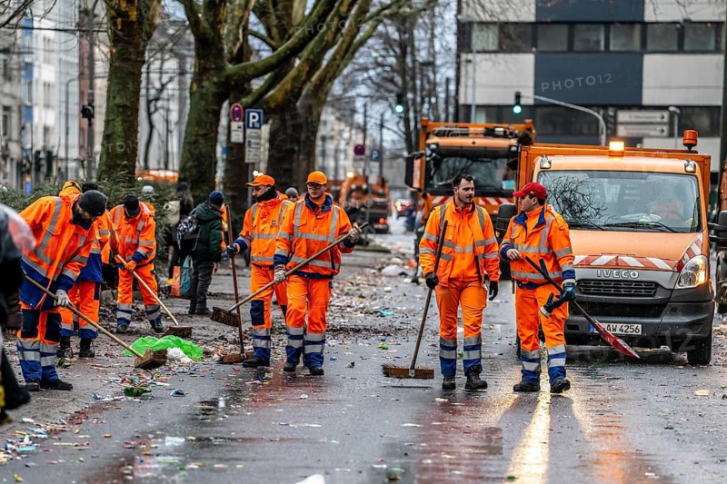 Sweep on Rose Monday in Düsseldorf, the municipal utilities clean up after the train, confetti, camels, trash, employees of AWISTA, Society for Waste Management and City Cleaning, central disposal and urban cleaning companies in Düsseldorf, clean the train's path with their street cleaning machines, North Rhine-Westphalia, Germany