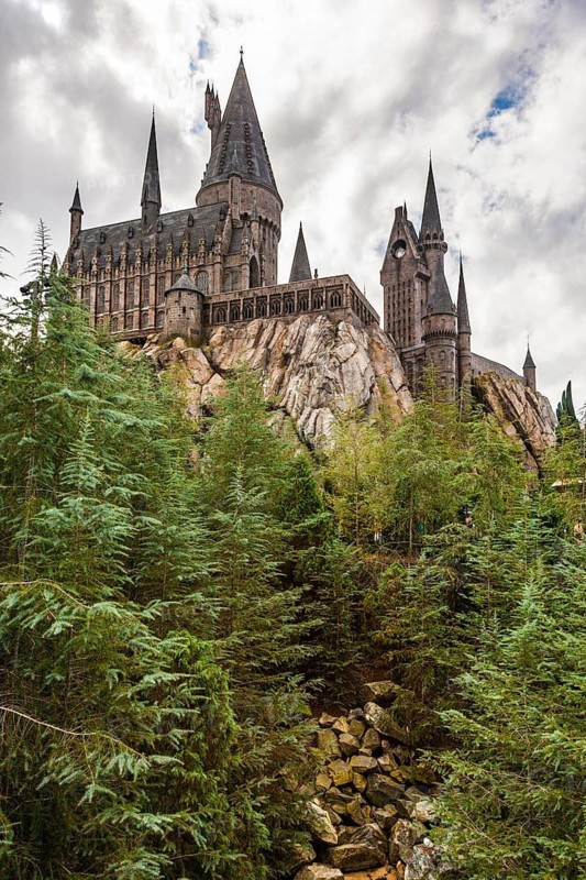 Hogwarts Castle rises above pine trees at The Wizarding World of Harry Potter in Universal Studios, Orlando, Florida, USA
