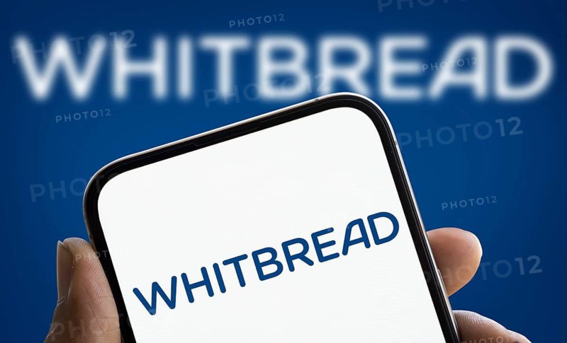 Whitbread logo is displayed on smartphone. Whitbread is a British multinational hotel and restaurant company.
