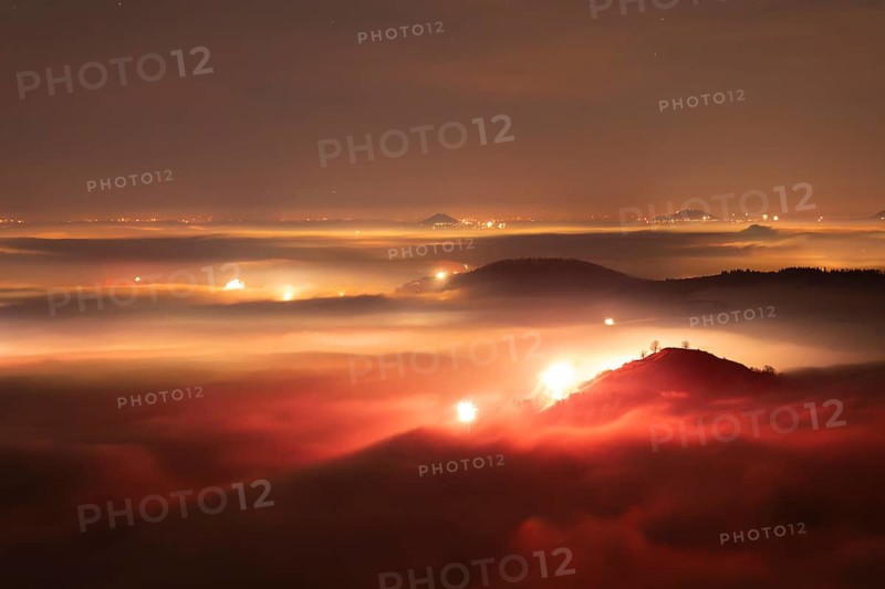 New Year's Eve fireworks 2024 on the Breitenstein, Swabian Alb near Ochsenwang. Sea of fog in the foothills of the Alb. View of the Drei Kaiserberge near Göppingen. In the foreground the Limburg and the Aichelberg