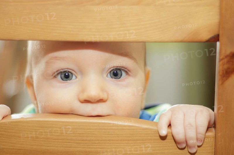 Small kid hiding on the chair back. Poznan, Poland