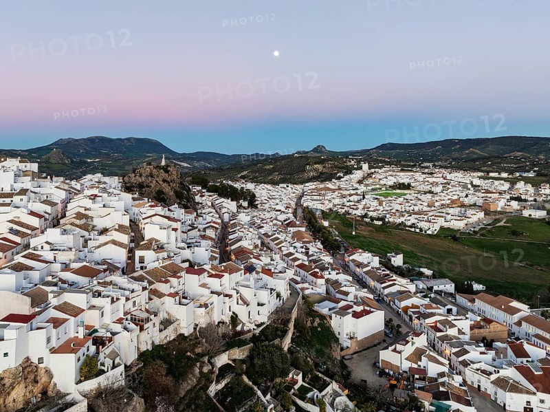The White Town of Olvera with full moon at dusk. Aerial view. Drone shot. Cádiz province, Andalusia, Spain