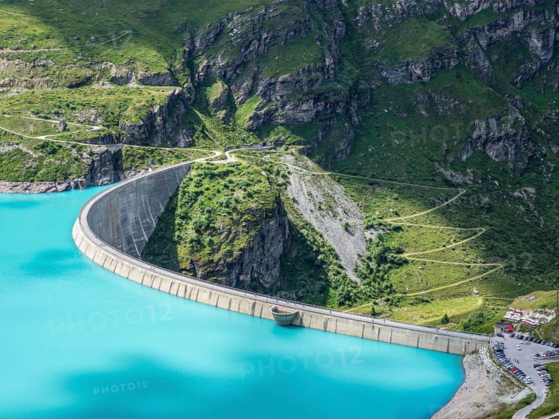 Dam of the Moiry lake, Lac de Moiry, turquoise glacial water, parking lot and restaurant at the dam, aerial view, Valais, Switzerland