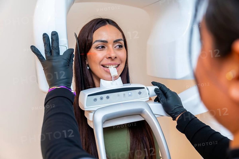 Dentist taking a dental x ray of a young woman in a modern dental clinic, ensuring accurate diagnostics for optimal treatment