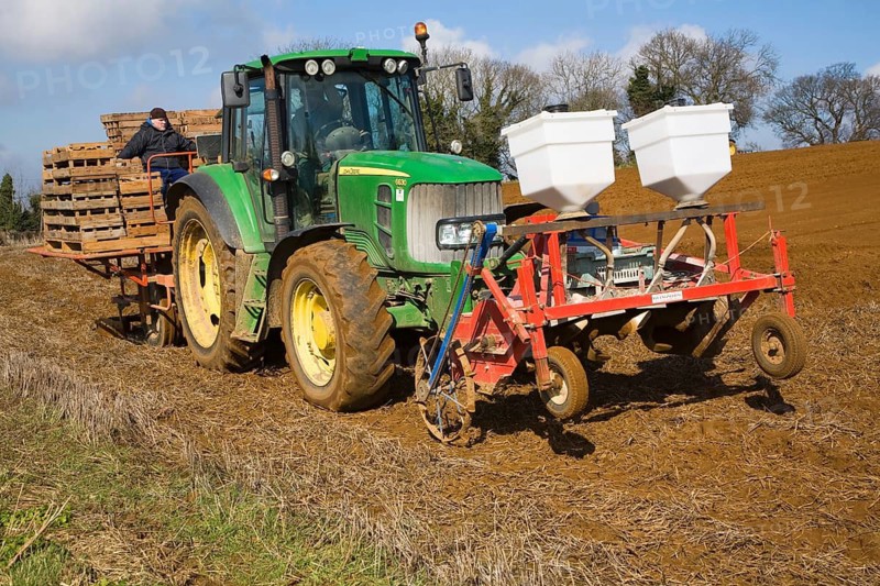 Farm machinery planting a crop of potatoes in a field, Shottisham, Suffolk, England, United Kingdom