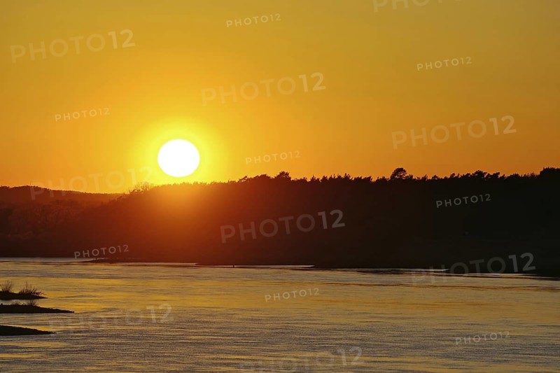 Sunset over a river with orange sky and forest silhouette, Elbe, Dömitz, Wendland, Lower Saxony, Mecklenburg-Western Pomerania, Germany