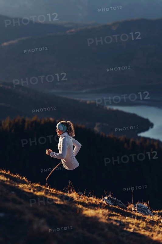 Trail running in autumn on the Jochberg on Lake Walchensee against the wonderful backdrop of the Alps, Bavaria, Germany
