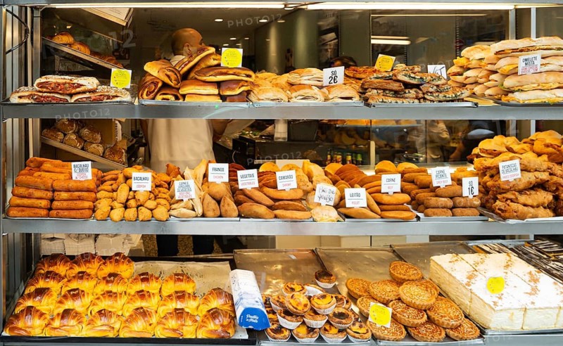 Variety of cakes and snacks on display in bakery shop, city of Porto, Portugal