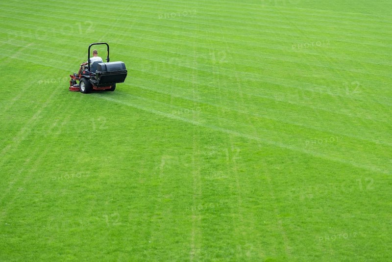 Mowing grass at football pitch in Lubin, Poland