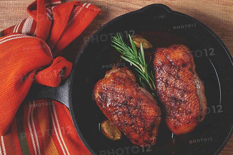 Roast duck breast, in a frying pan, with spices and herbs, close-up, no people