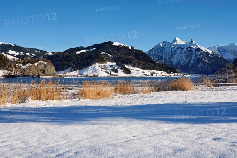 Frozen Sihlsee, reservoir, behind the snow-covered mountains Flübrig and Druesberg, Euthal, Canton Schwyz, Switzerland