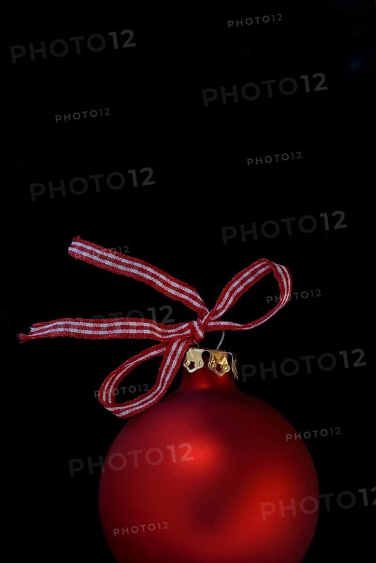 Red Christmas tree bauble with bow on a black background