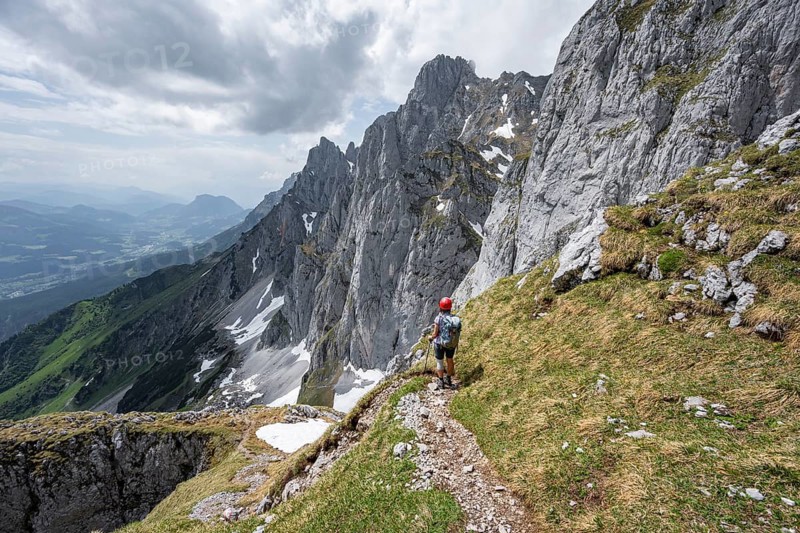 Mountaineer with helmet on a hiking trail, descent from the Maukspitze, rocky mountain peaks with Törlspitze in the background, Wilder Kaiser, Kaiser Mountains, Tyrol, Austria