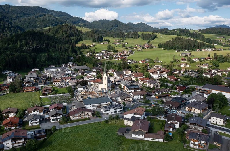 Drone shot, view of the village with parish church, Kössen, Leukental, Tyrol, Austria