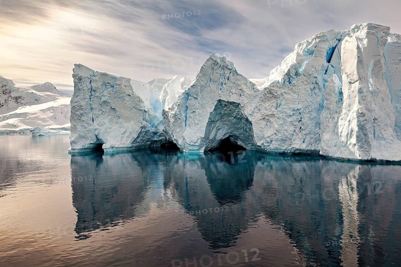 Iceberg formations are reflected in the calm water and create a mystical atmosphere, icebergs in the landscape of the Southern Ocean in Antarctica