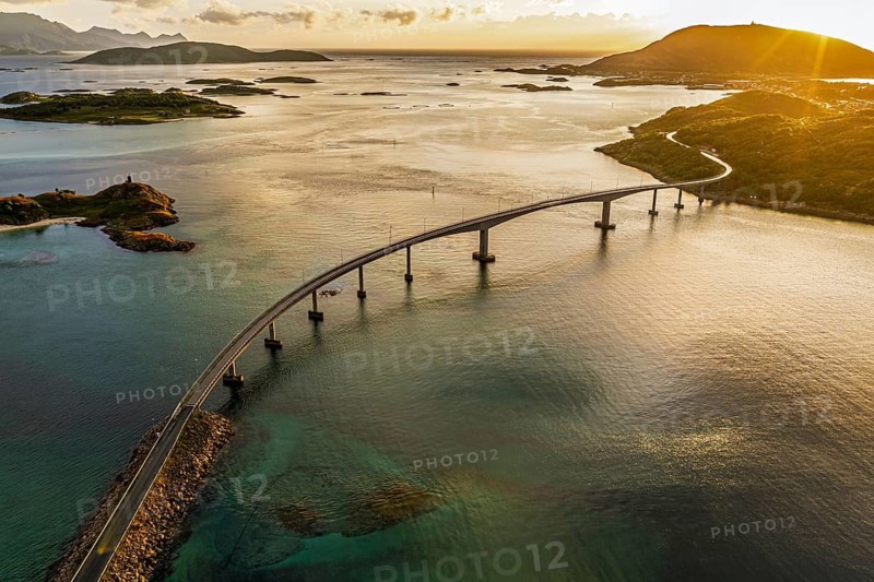 Sommaroy Bridge connecting Kvaloya Island to Sommaroy Island, warm light at sunset, aerial view, Norway