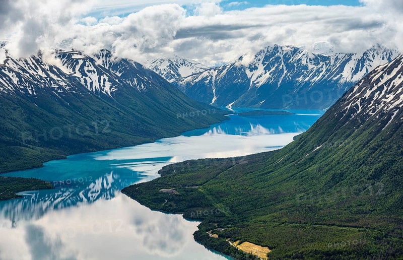 View of snowy mountains in spring and turquoise Kenai Lake with reflection, Slaughter Ridge Trail, Cooper Landing, Kenai Peninsula, Alaska, USA