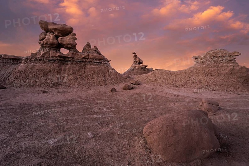 Explore the unique sandstone formations of Goblin Valley State Park, Utah, at sunset. Soft orange and pink hues create a surreal landscape in this breathtaking natural wonder