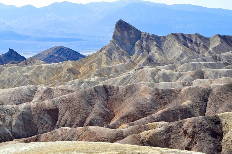 Rugged mountain landscape with distinctive rock formation under blue sky, Zabriskie Point, Death Valley National Park, Mojave Desert, California, Nevada, USA