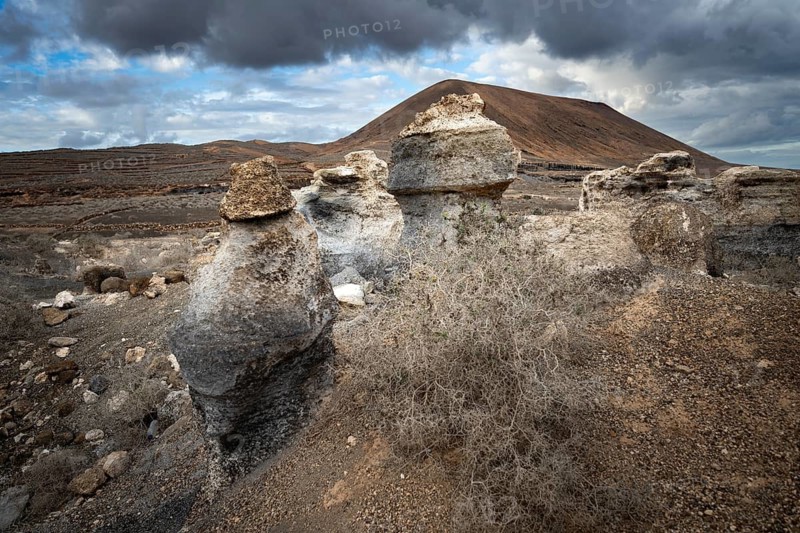 Eroded rock formations, volcanic landscape with dramatic cloudy skies, Ciudad Estratificada or Los Roferos, Antigua Rofera de Teseguite, Lanzarote, Canary Islands, Spain