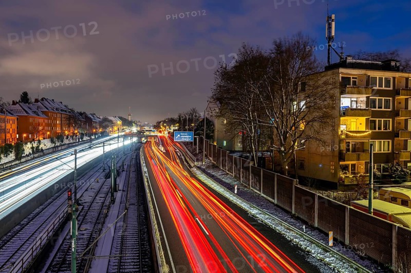 Autobahn A40, Ruhrschnellweg, near Essen at the Frohnhausen junction, evening traffic in winter, residential buildings directly on the 4-lane motorway, North Rhine-Westphalia, Germany