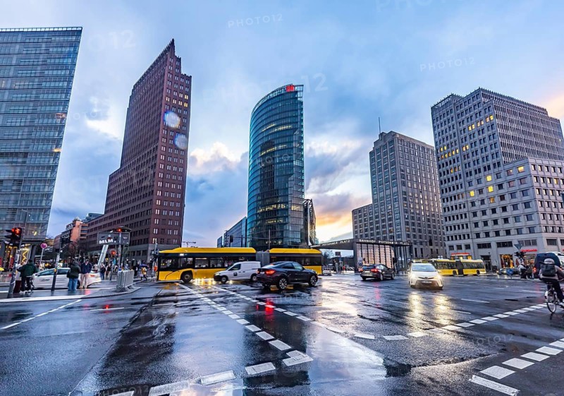 Potsdamer Platz Berlin in the evening with traffic on the streets. When it rains, the skyscrapers are reflected in puddles of water. Bahn-Tower, headquarters of Deutsche Bahn AG. Berlin, Germany