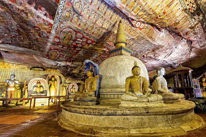 Interior of a cave with Buddha statues, a stupa and elaborate ceiling paintings, The cave temple of Dambulla in Sri Lanka