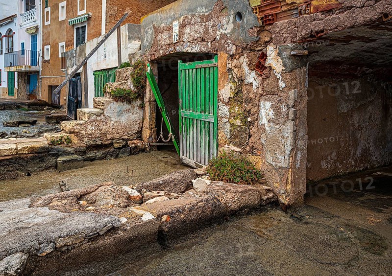 Old and dilapidated boat shelters that are not being used, old port area in Portocolom on the east coast of Majorca, Spain
