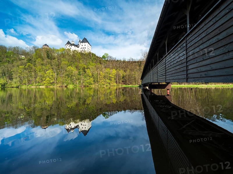 Burgk Castle and the covered wooden footbridge are reflected in the river Saale in spring, Burgk, Thuringia, Germany