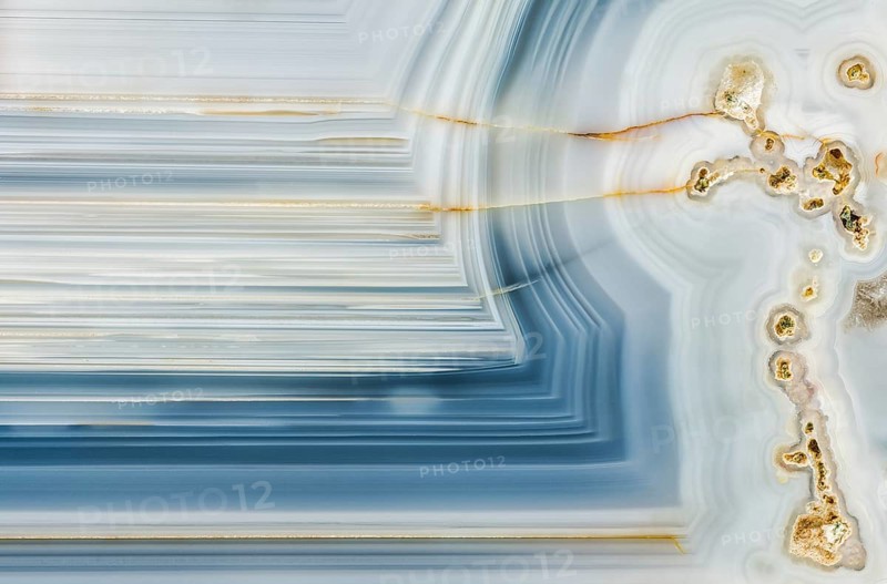 A macro photograph showcasing the striking linear patterns and mineral details inside a Whitcomb Creek geode from Oregon, highlighting its intricate crystal formations and smooth textures